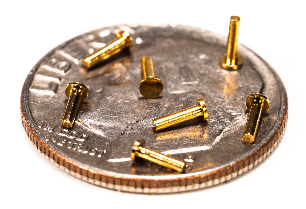 micro machined brass contact pins on a dime